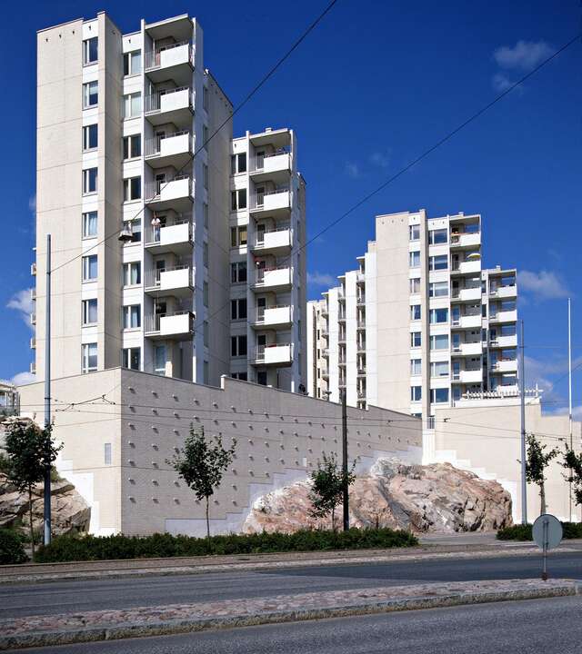 Stepped apartment buildings with brown tile and white panel elements.