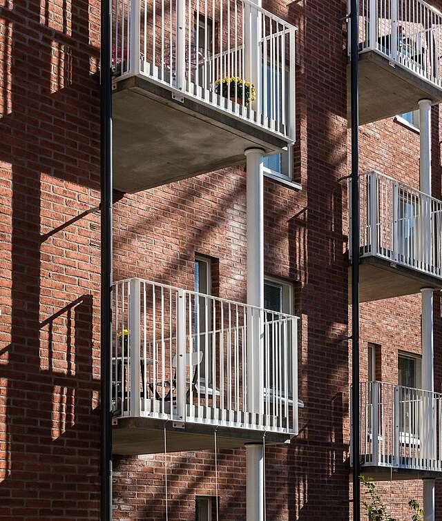 Red-brick building with white balcony railings.