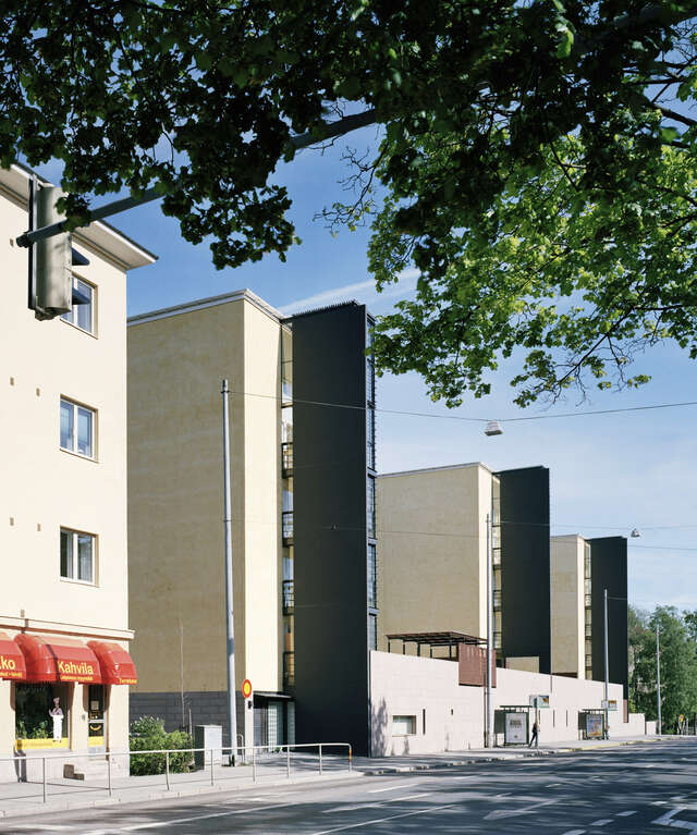 Apartment buildings with black protruding balconies from beige plastered buildings.