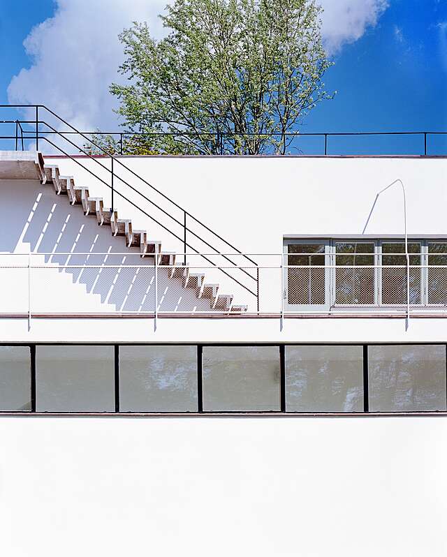 White outside wall with stairs leading to the roof.