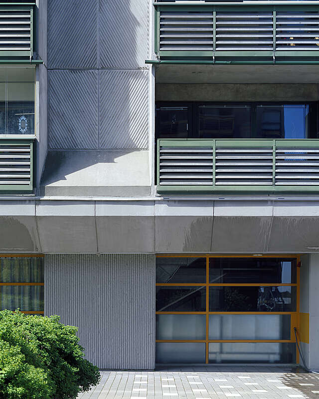 Entrance level with profiled concrete elements, aluminium balcony railings and steel-framed glass