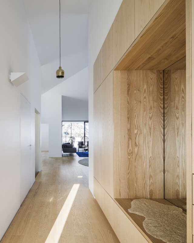 A hallway inside of a house. A large wooden element is seen on the right.