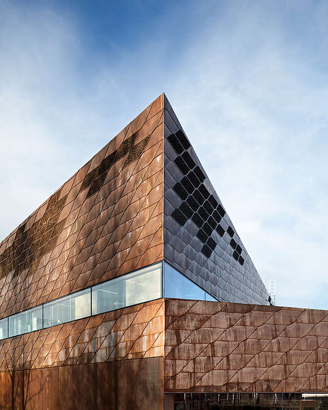 Detail of a dark copper façade with ribbon windows