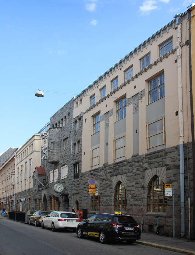 Stone building with the upper floors covered in beige plaster.