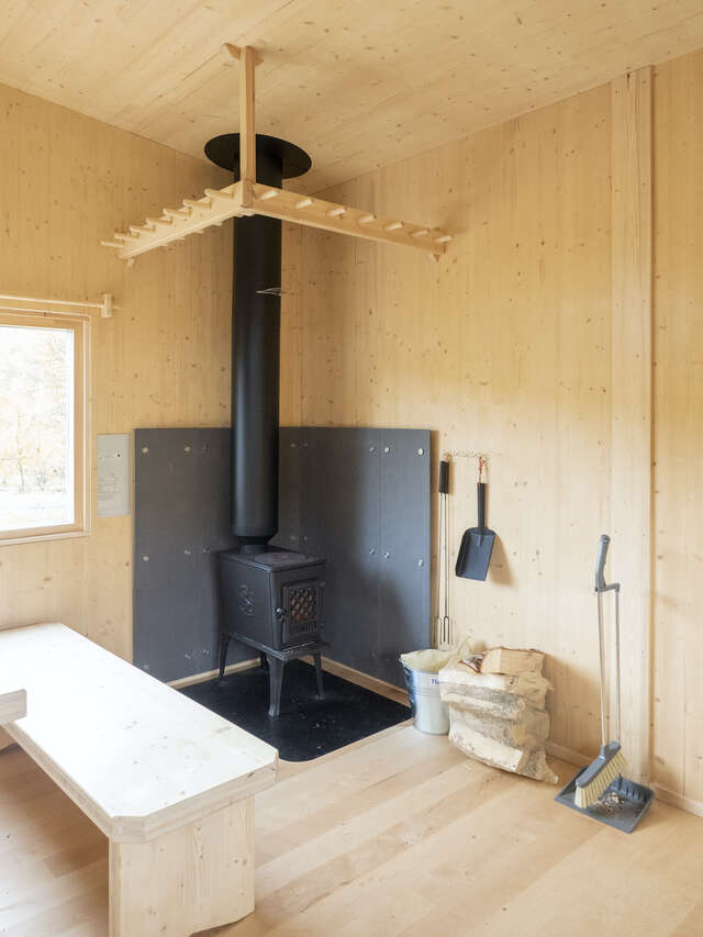 A metal fireplace in a wooden room