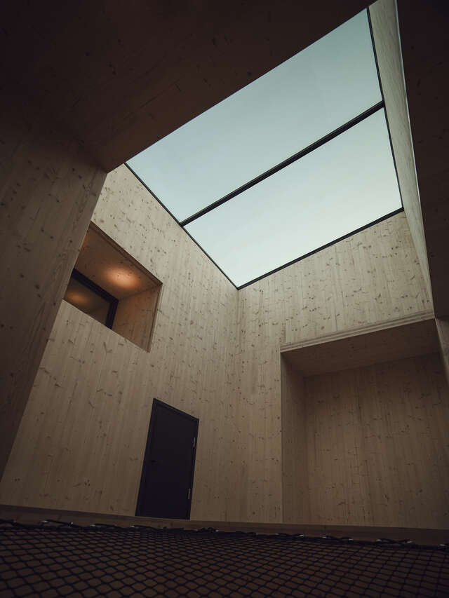 Room with wood walls and glass ceiling.
