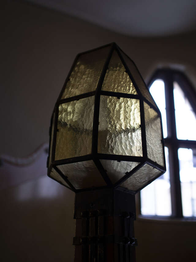 Lantern made of small triangular and rectangular pieces of yellow tinted glass that rejoined together by metal.