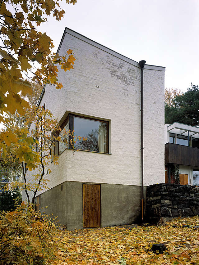 Corner of the house with a wooden door and a big window