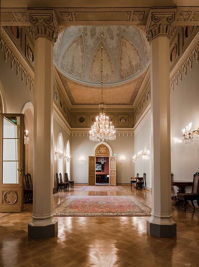 Waiting hall with ornate walls and a ceiling with paintings