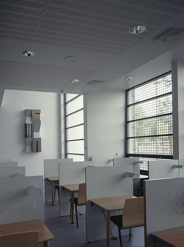 Singular tables with a reading light in a white room.