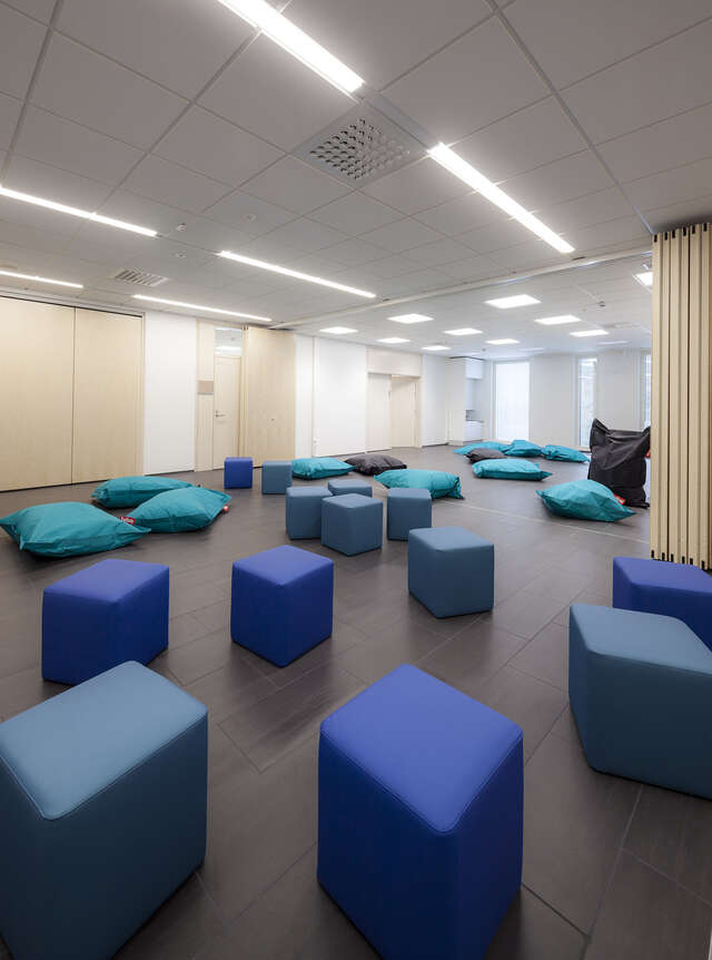 Room with bean bags and blue benches.