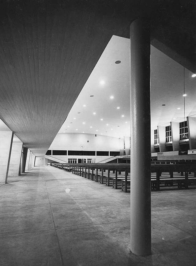 Interior of the Sports hall filled with wooden benches.