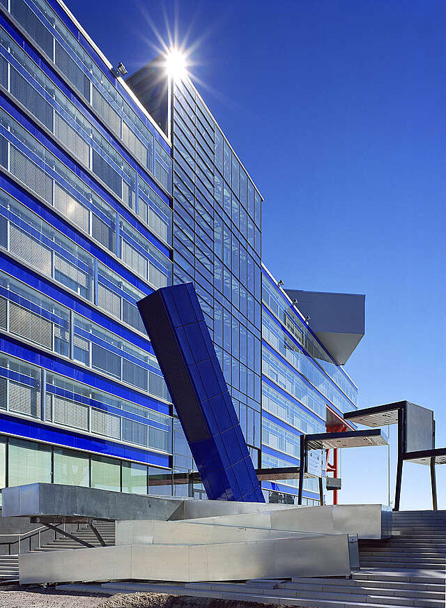 Tall office building with glass and blue elements.