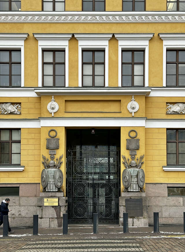two statues depicting soldiers ingrained to the facade of the building.