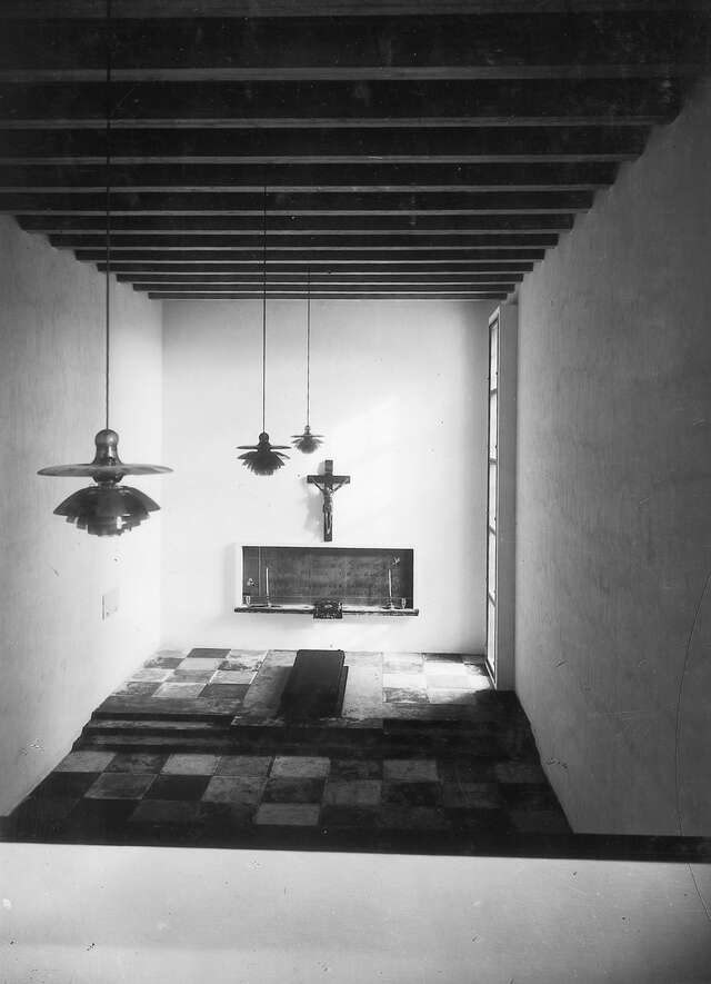 White room with checkered tile floors and three hanging lamps.