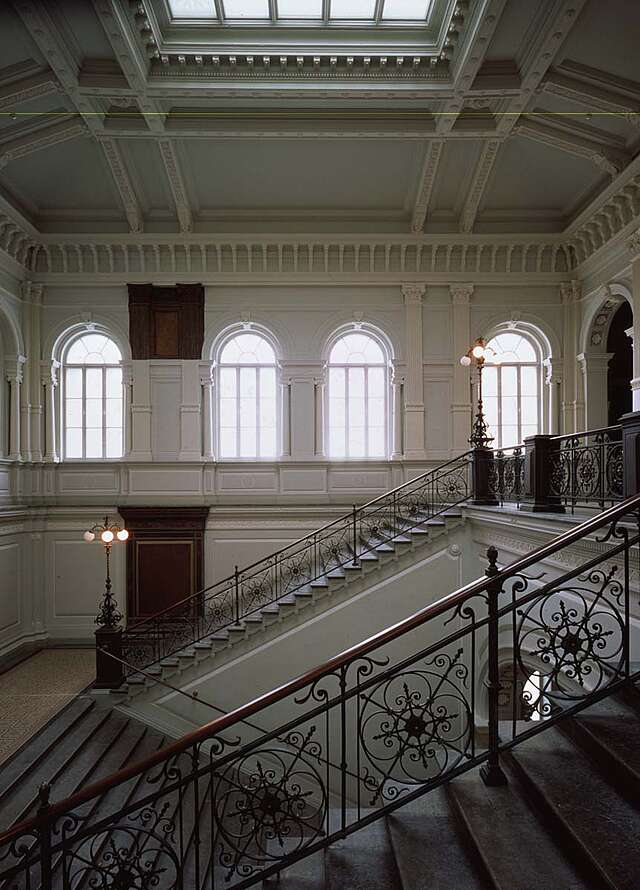Stone staircase with a metal railing with a circular pattern.