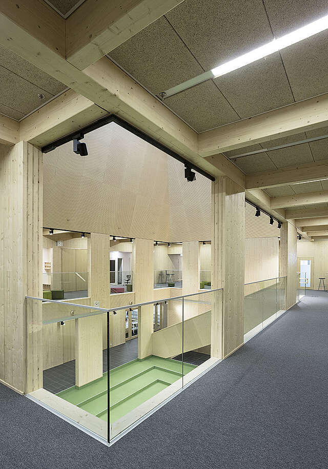 View of the hall with high ceiling in the middle of the space, viewed from the second floor.