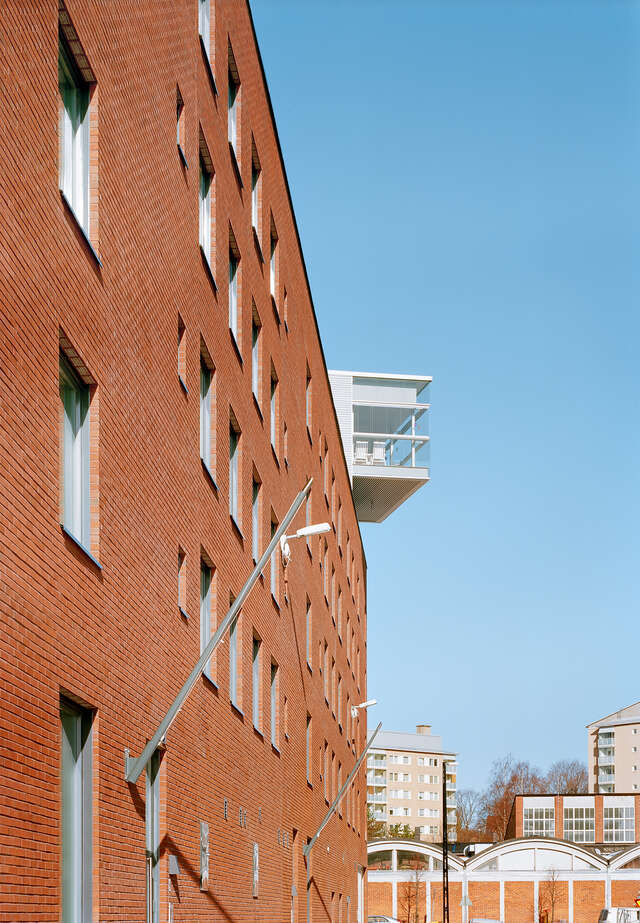 Red brick façade with a white extruding balcony