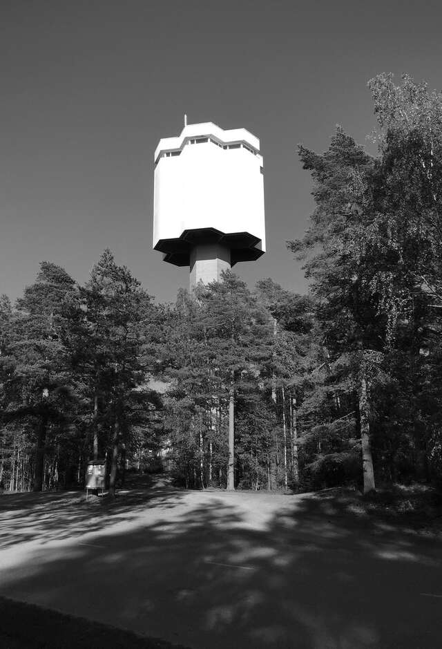 Water tower in brutalist style building has a honeycomb-shaped hexagon distributor reservoir.