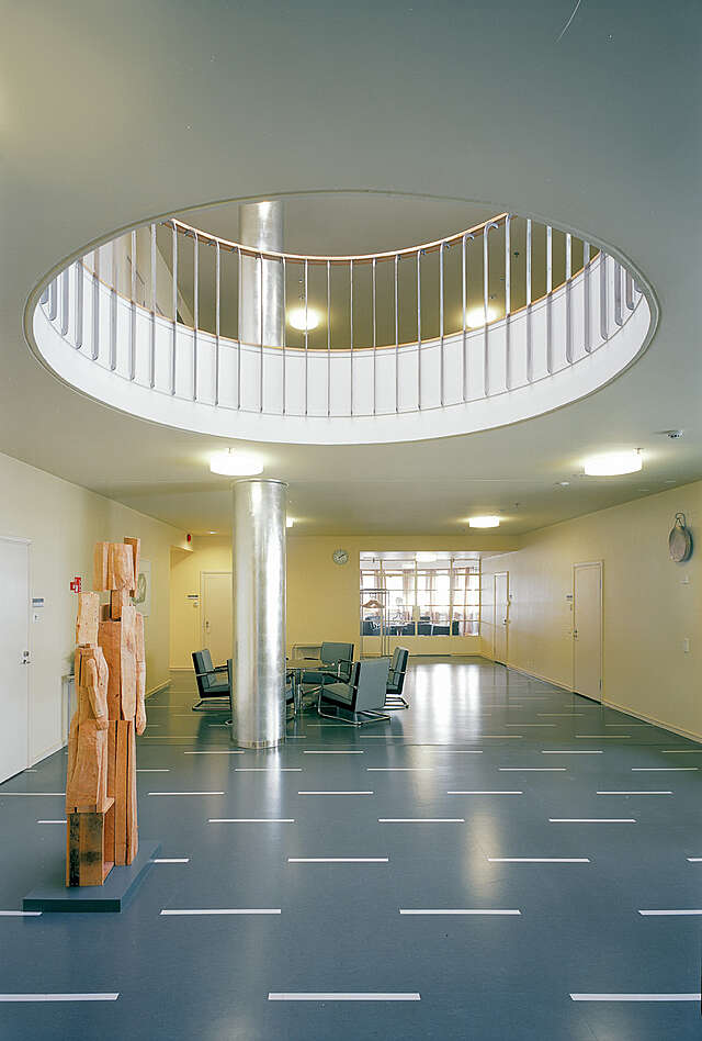 Hall with sculpture and a round hole in the ceiling displaying the upper floor.