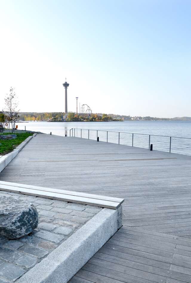 A large wooden deck next to a body of water