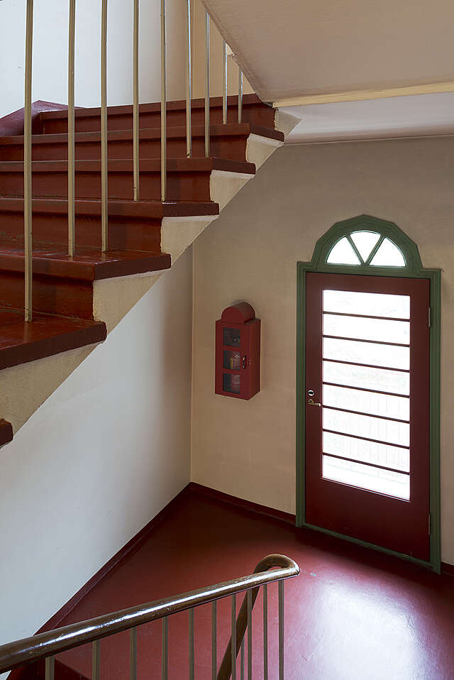 Red and white staircase with a glass door