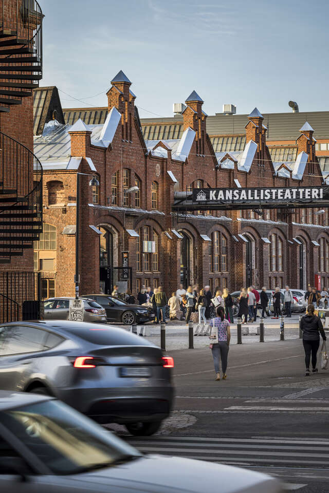 An old industrial brick building on a bustling street.
