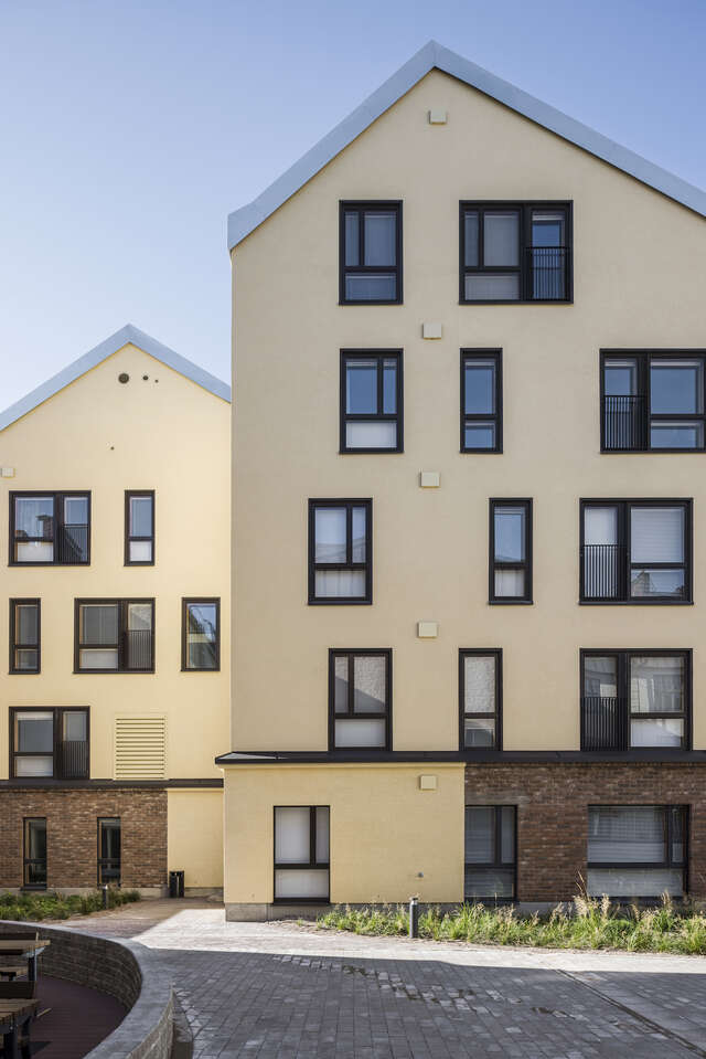Two yellow apartment buildings with scattered windows.