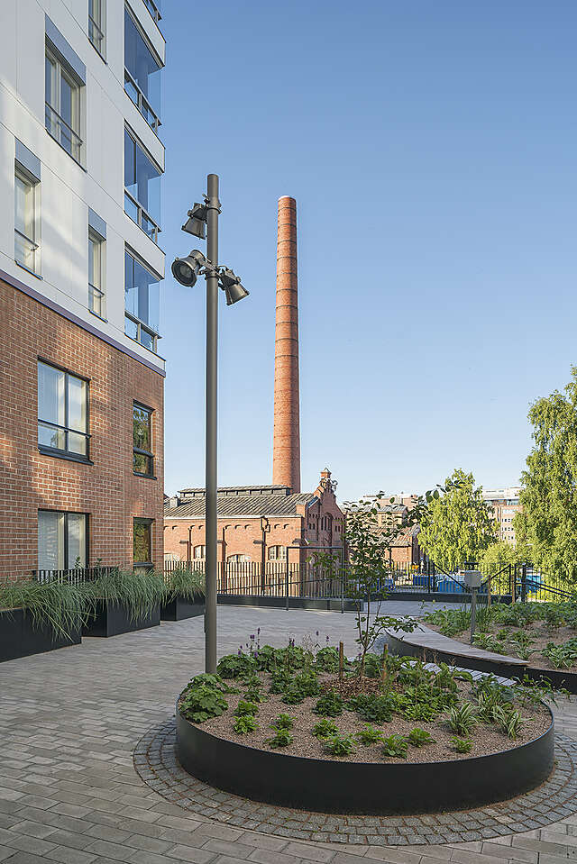 large circular pla ter in the middle of a yards industrial building with a tower is visible in the background.