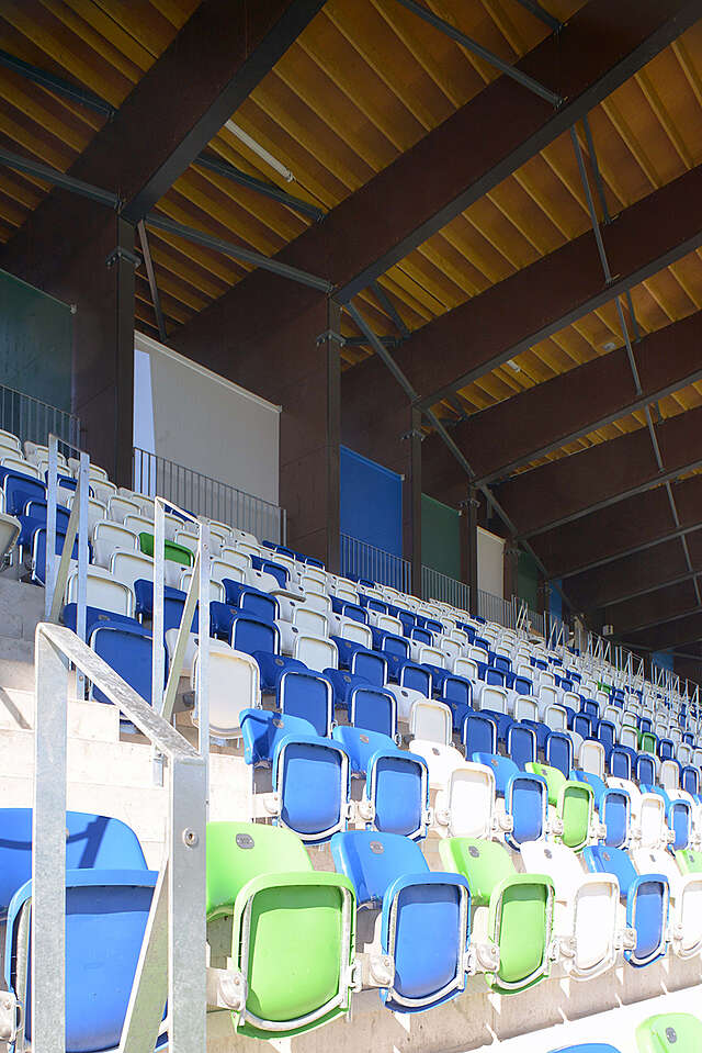 Rows of blue white and green plastic seats for the audience.