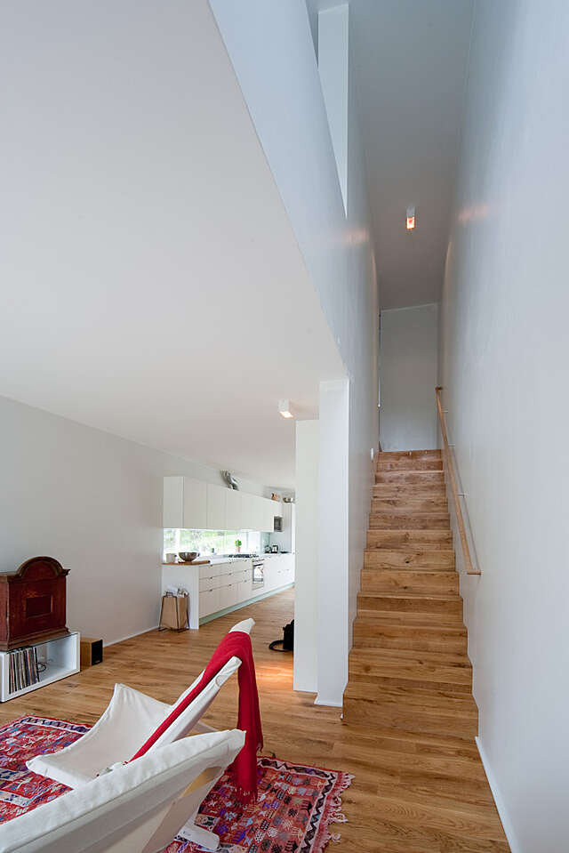 White interior with wooden floors and stairs.