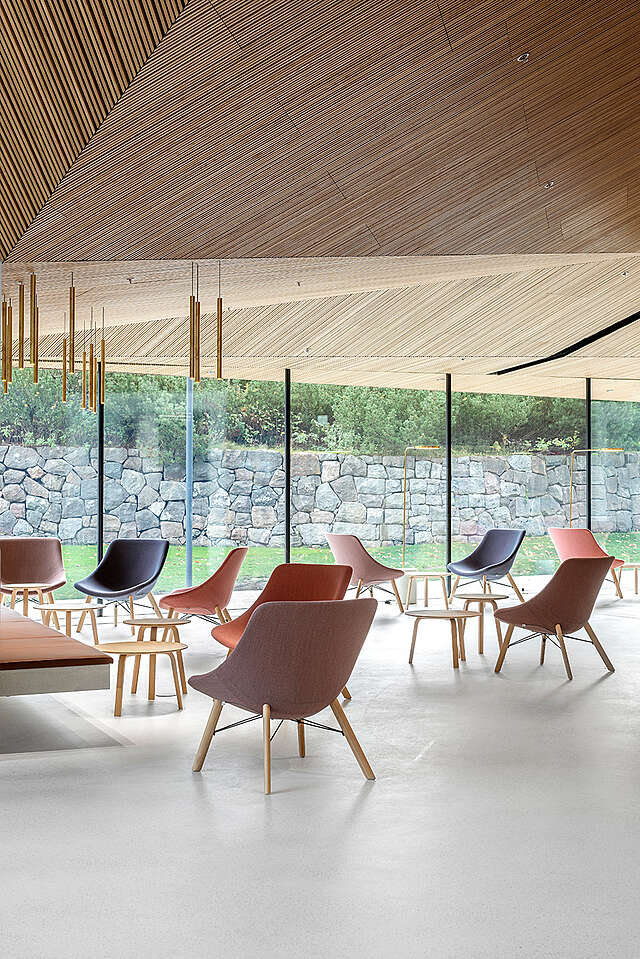 Low wooden ceiling, full-hight windows with view towards stone barrier, armchairs