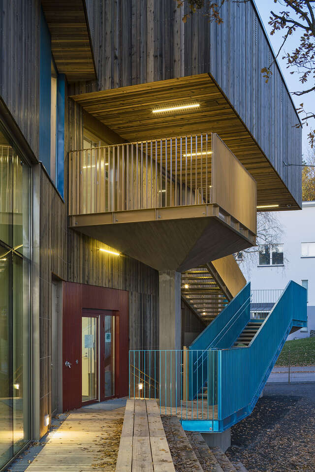 Blue painted outside staircase next to the wooden building.