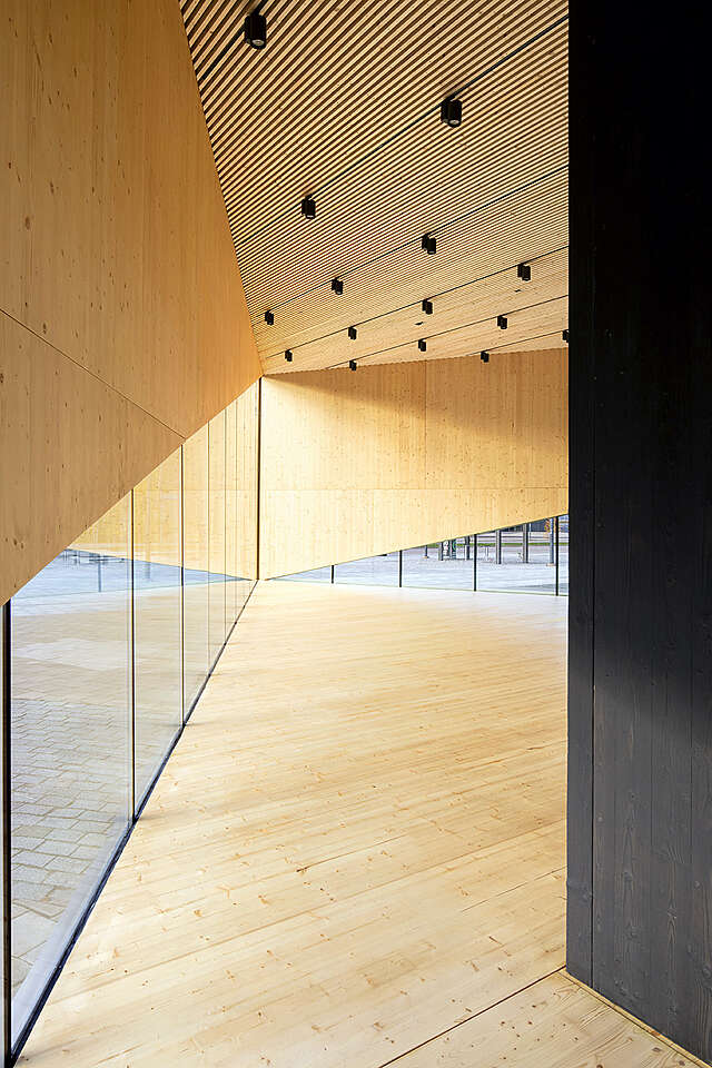 An empty space with wood ceilings and glass walls.