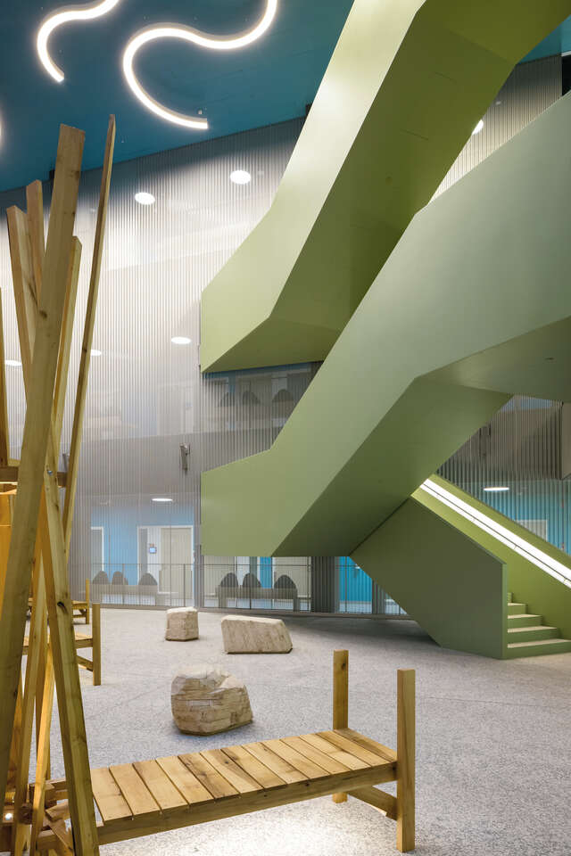 A green-coloured staircase going up multiple floors.