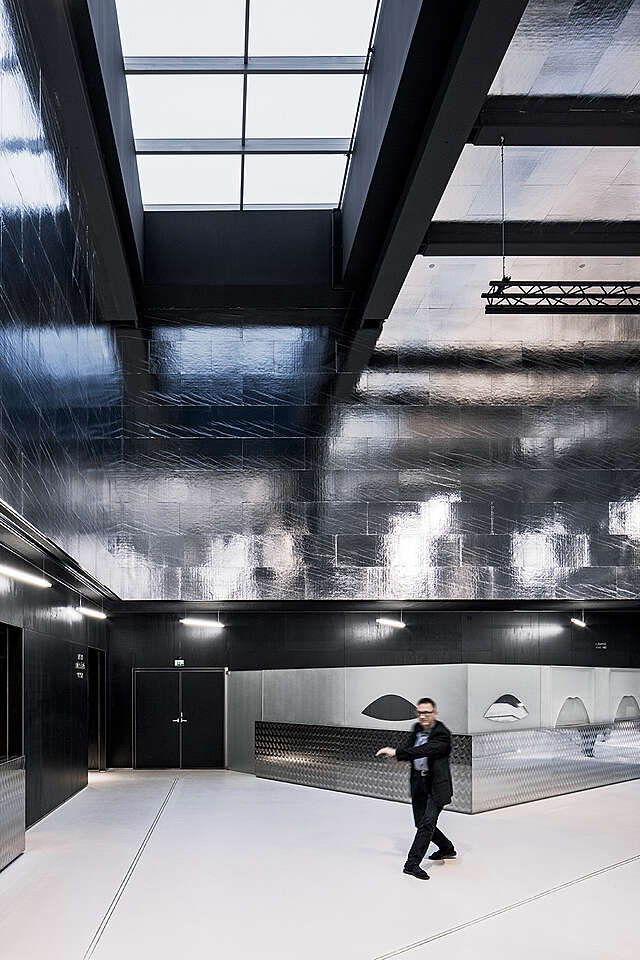 Dark foyer with metallic walls and ceiling.