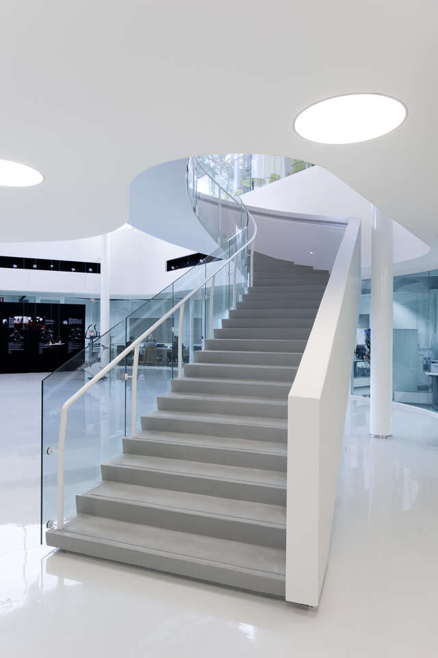 Grey staircase with white and transparent railings