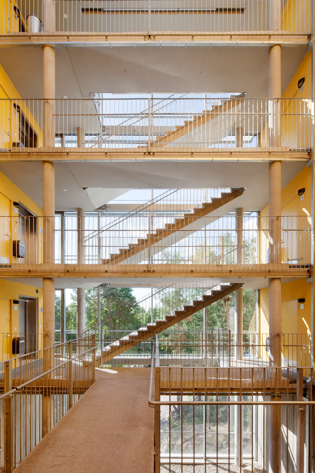 Photo of three-storey hall, which has stairs. There is a window behind the stairs.