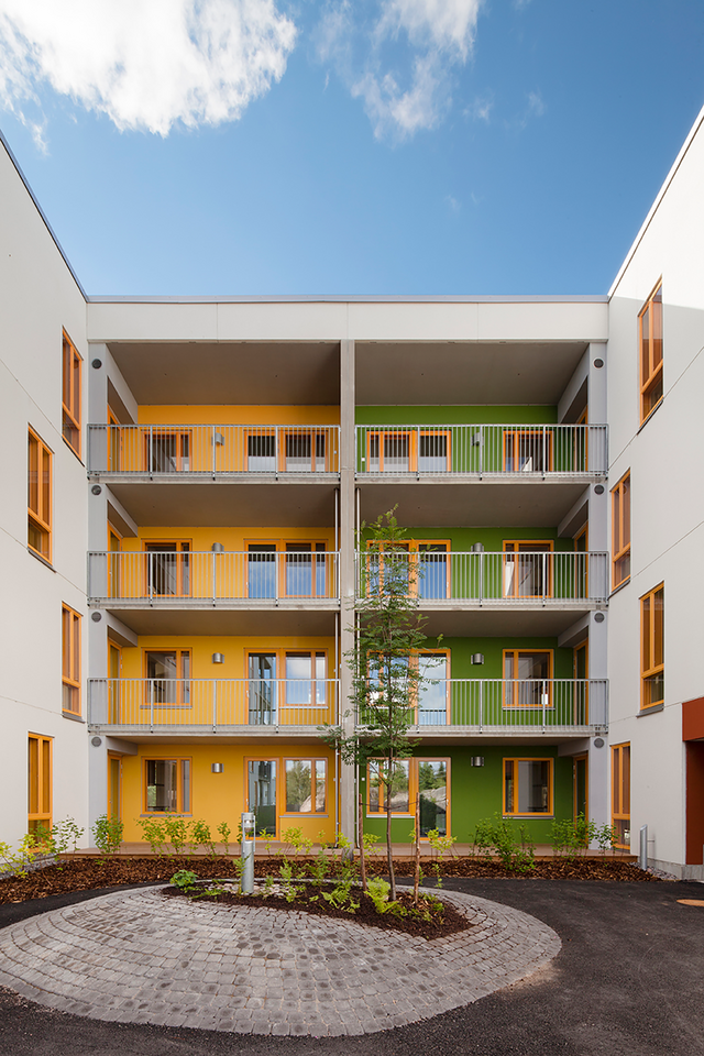 Multi-colored apartment building with balconies.