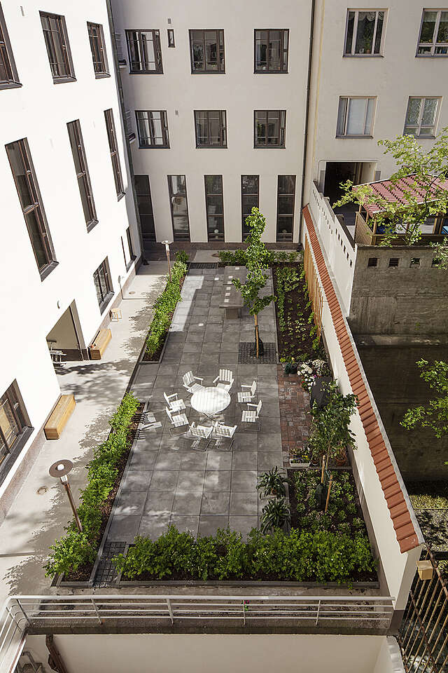 Green courtyard surrounded by white apartment buildings.
