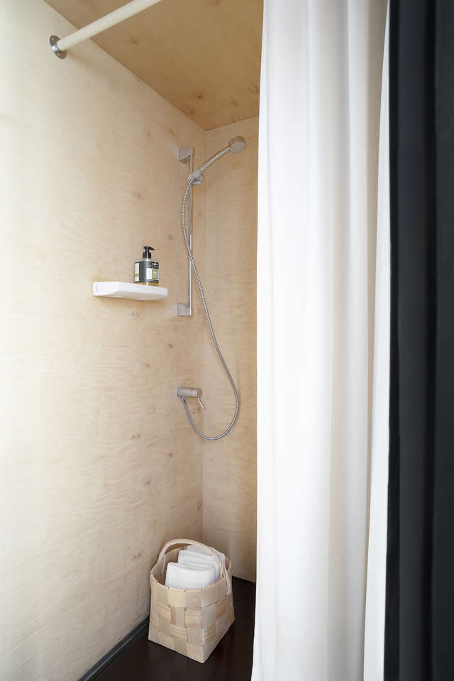 A small shower in a wooden bathroom