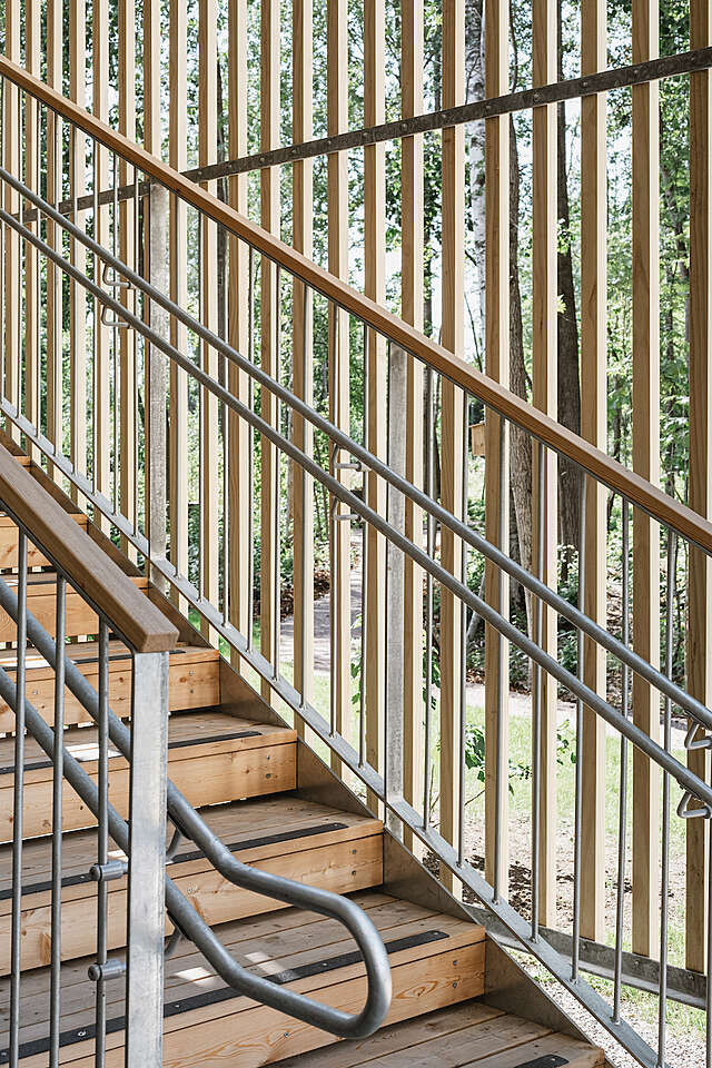 Details from a wooden stair railing, with forest landscape in the background