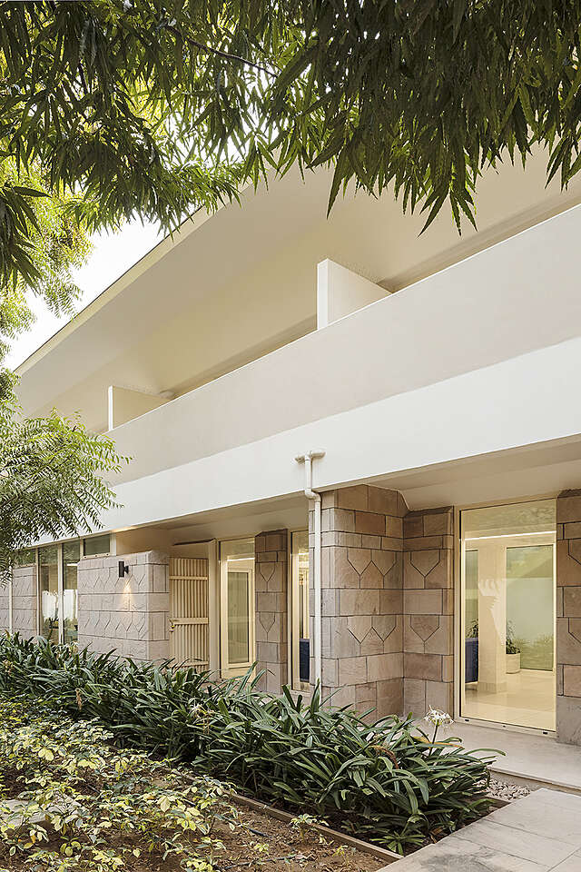 Back entrance with a balcony above it and garden
