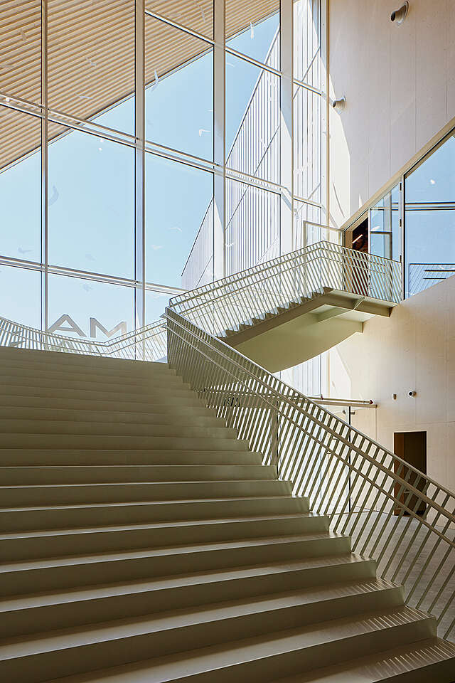 Staircase next to wooden surfaces and a glazed wall