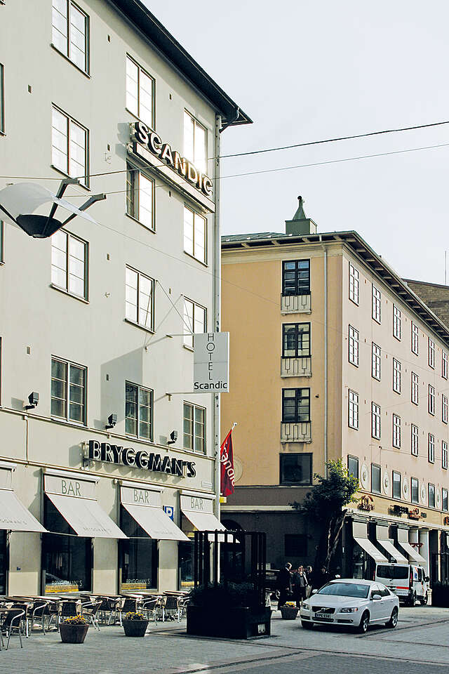 City street view with a white and terracotta building at the left.