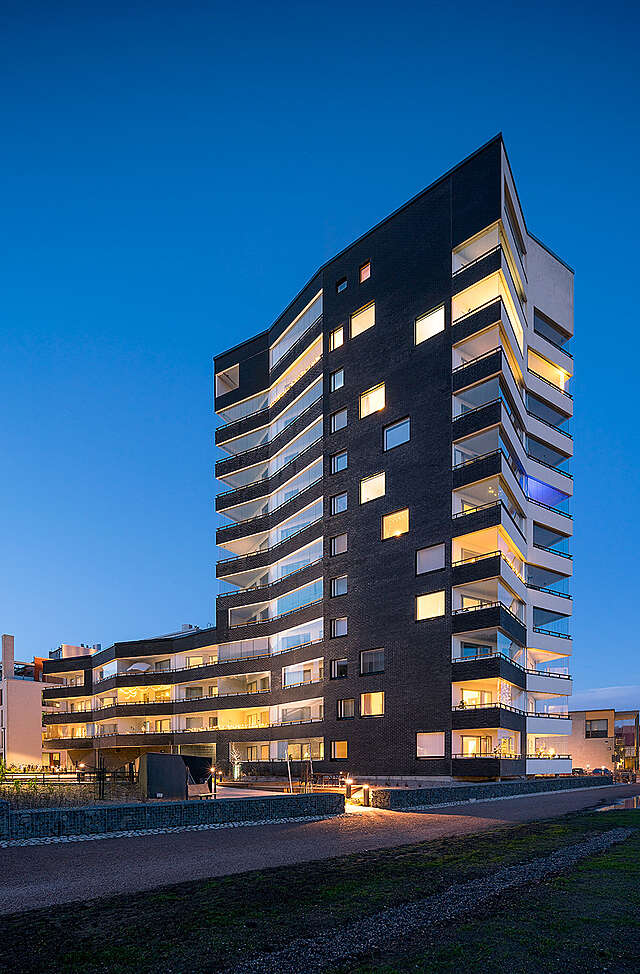 Black and white apartment building facade with sharp corners and no straight lines.