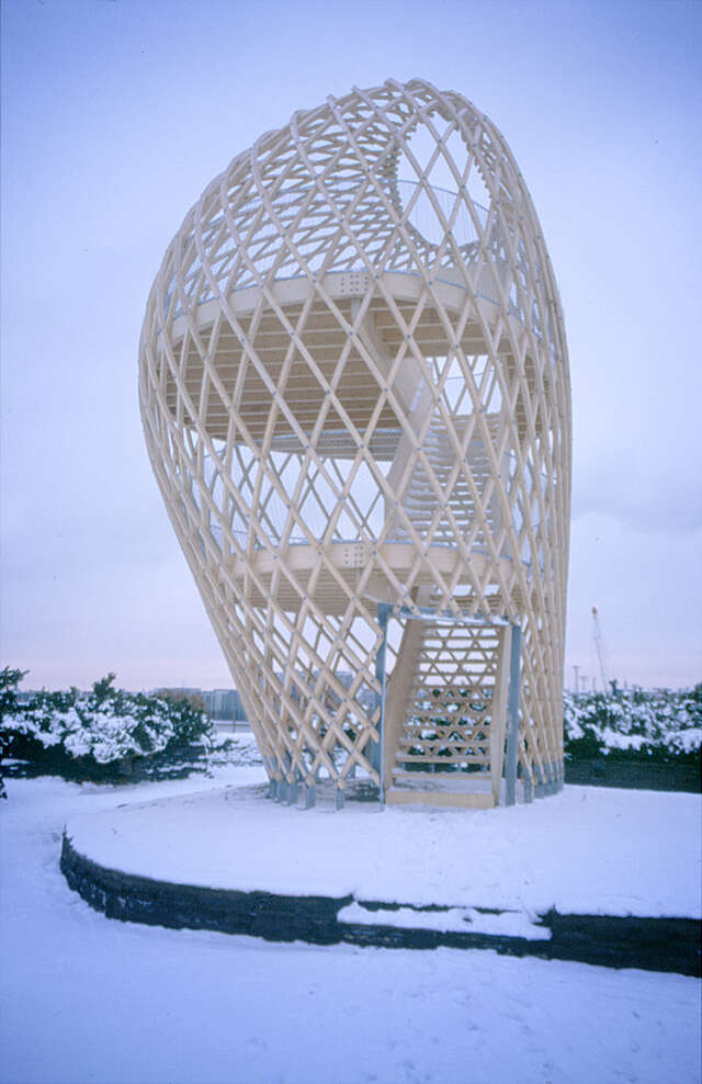 Wood sculptural observation tower with a grid detail in a snowy landscape.